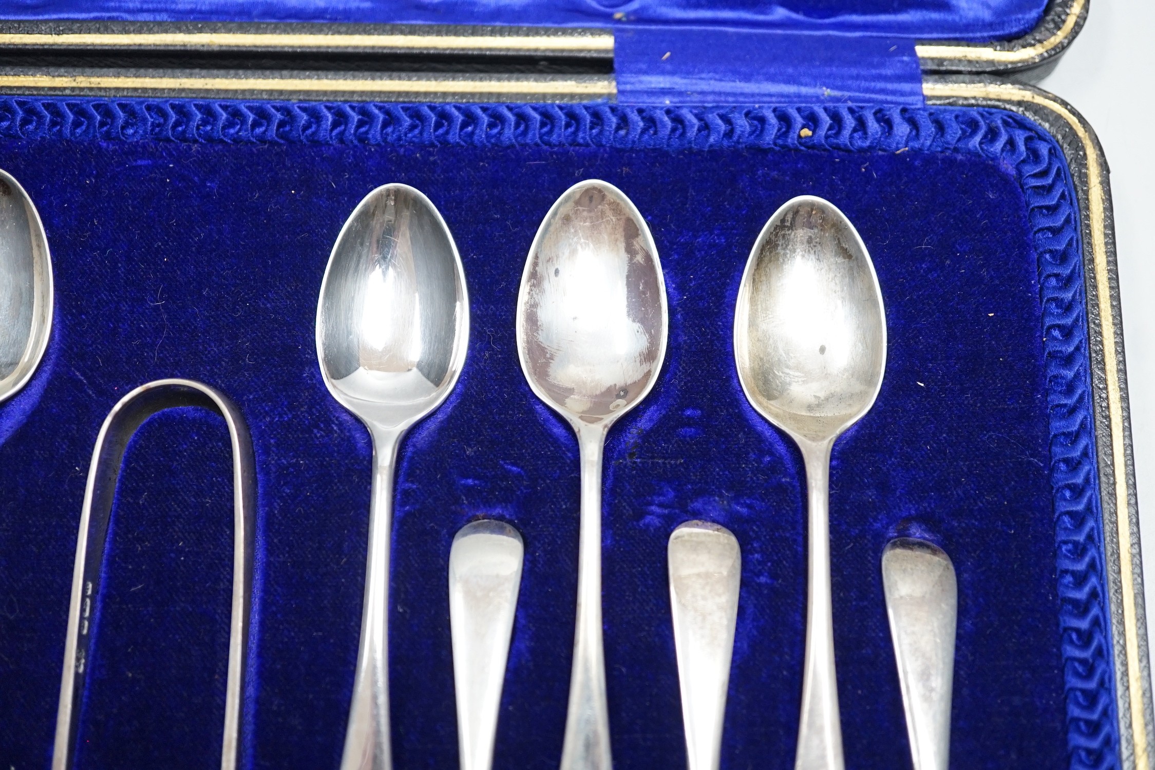 A set of twelve Edwardian silver Old English pattern teaspoons and tongs, Sheffield, 1909.